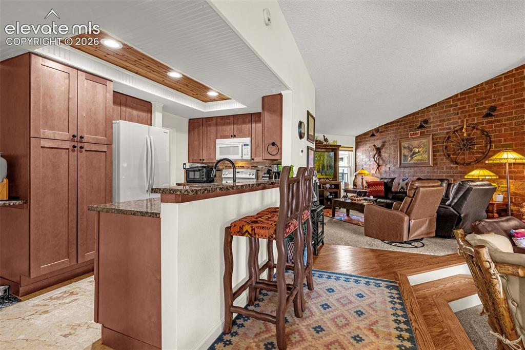 Image 9 of 21: Beautifully updated kitchen with breakfast bar, ample storage and inset lig