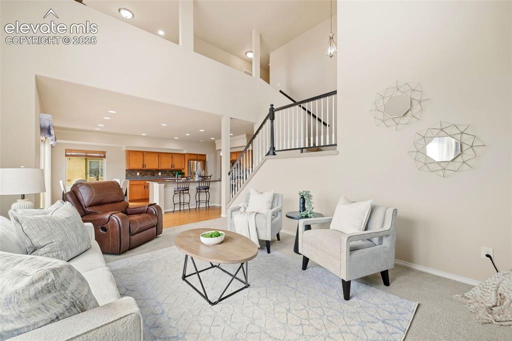 Image 11 of 40: Open living room with high ceilings, tons of natural light, and a gas firep