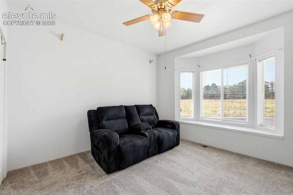 Image 14 of 25: Bay window with multiple panels, ceiling fan with integrated lighting, and 