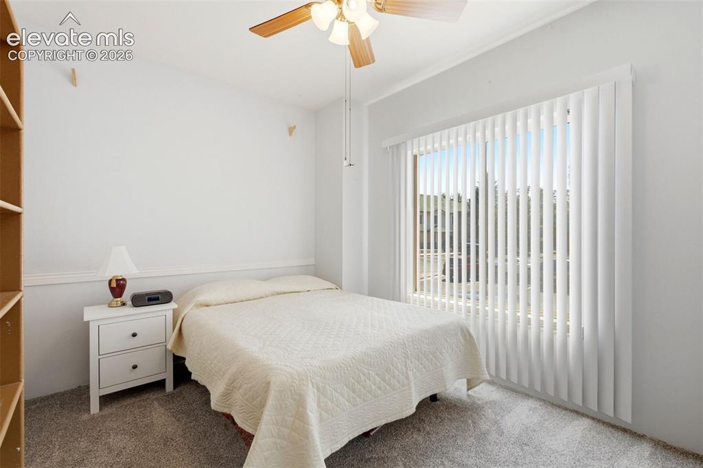 Image 15 of 25: Neutral wall color, wall-to-wall carpeting, ceiling fan with light fixture,