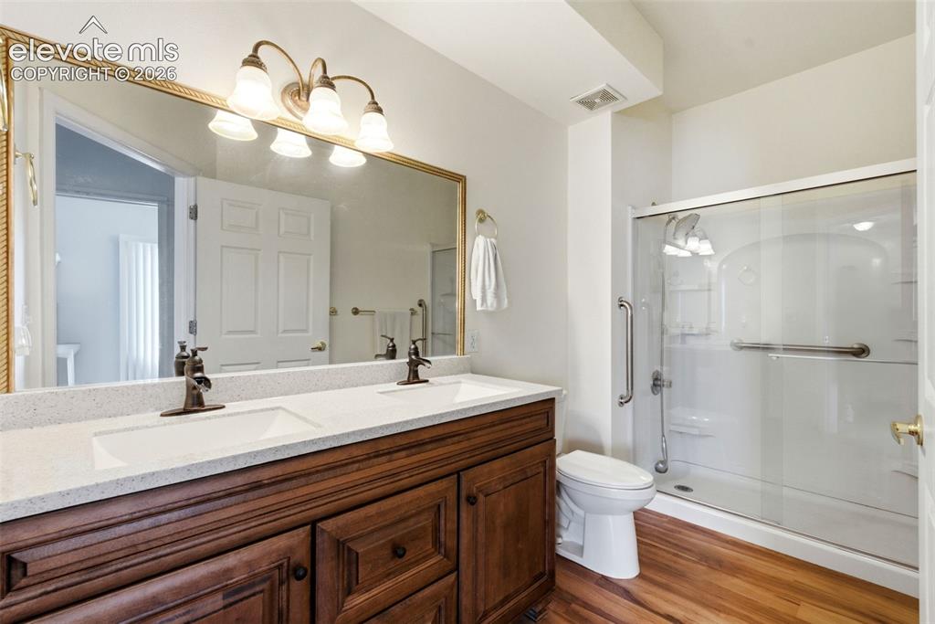 Image 16 of 25: Double vanity with white solid surface countertop and undermount sinks, bro