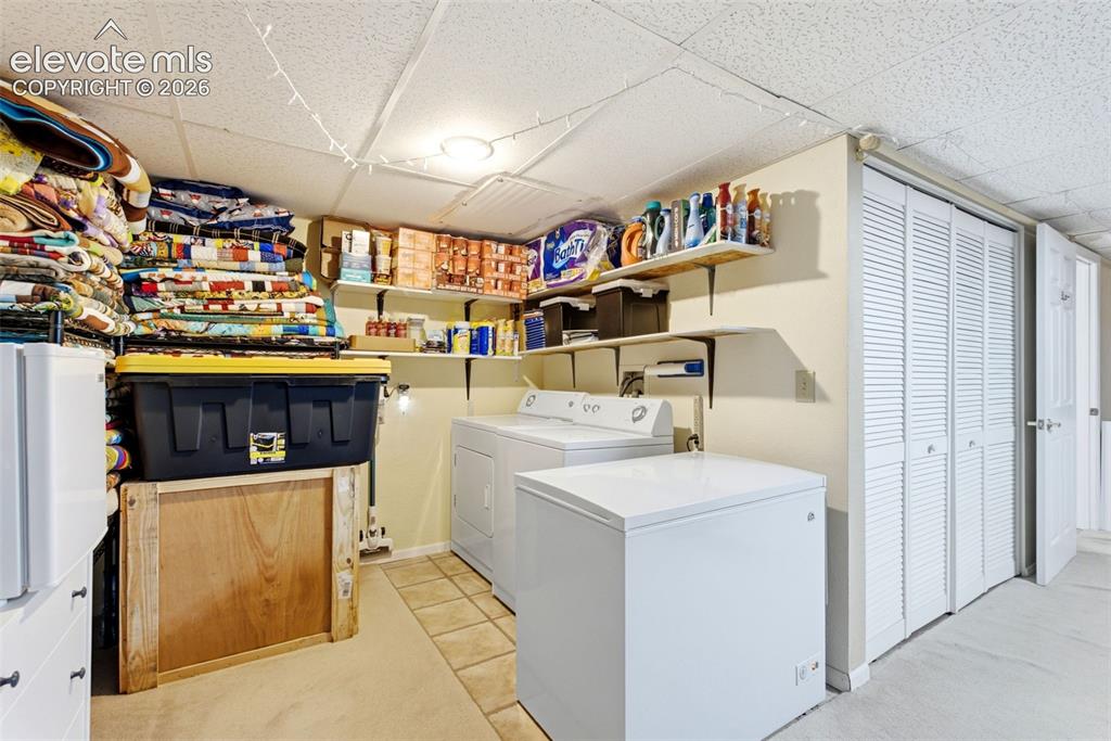 Image 18 of 25: Laundry area featuring a washer, dryer, and a chest freezer
