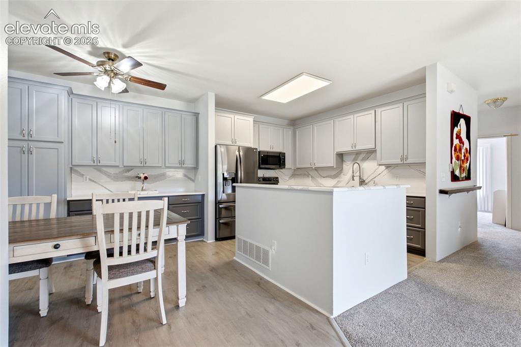 Image 4 of 25: Kitchen featuring light-toned cabinetry, stainless steel appliances, a cent