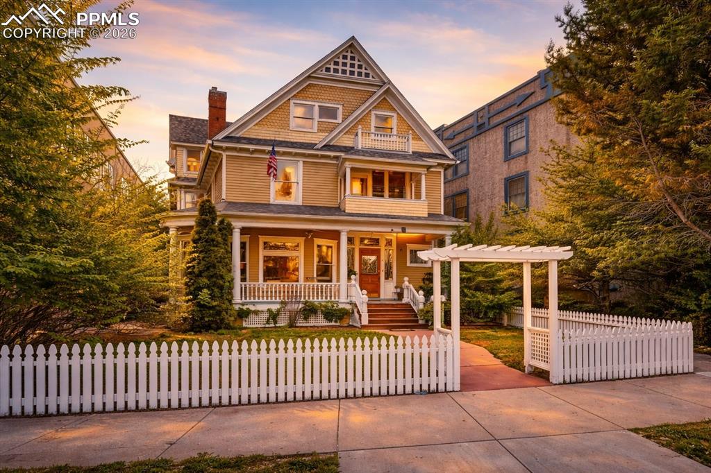 Image 1 of 50: Victorian-style residence featuring a welcoming front porch, white picket f