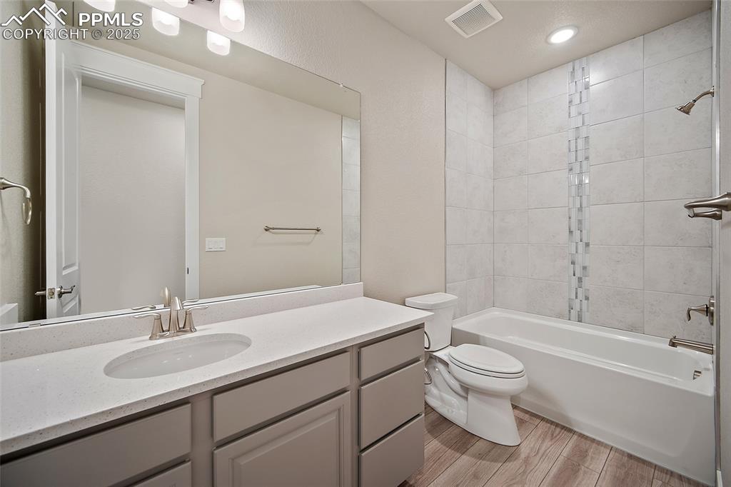Image 10 of 46: Bathroom with shower / bath combination, vanity, and light wood-style floor