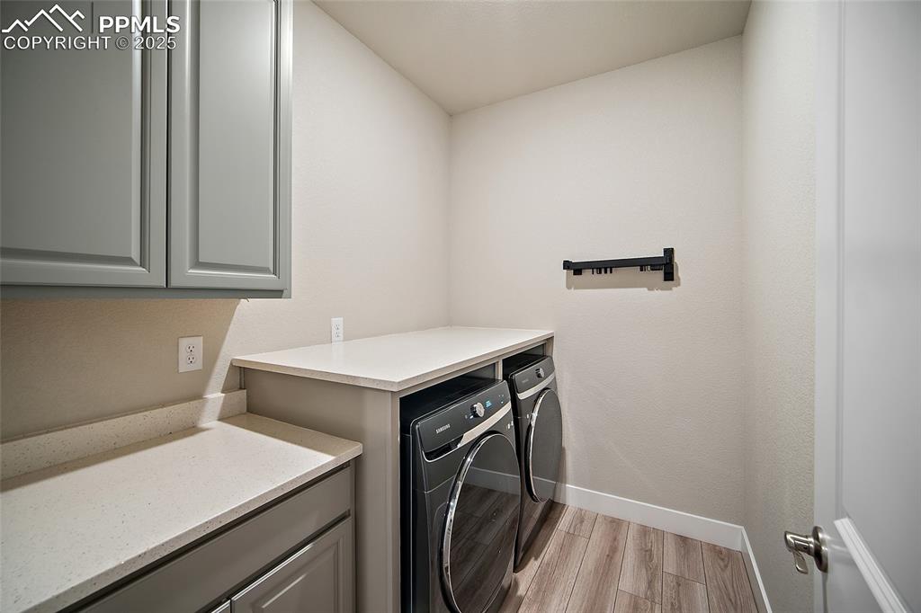 Image 12 of 46: Laundry room with light wood-type flooring and washing machine and clothes