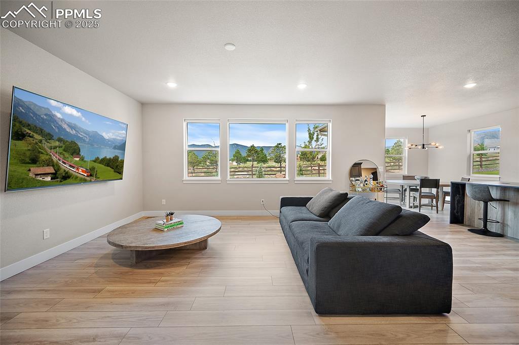 Image 14 of 46: Living room featuring light wood-type flooring and recessed lighting