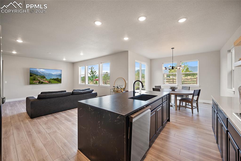Image 19 of 46: Kitchen with a kitchen island with sink, open floor plan, decorative light