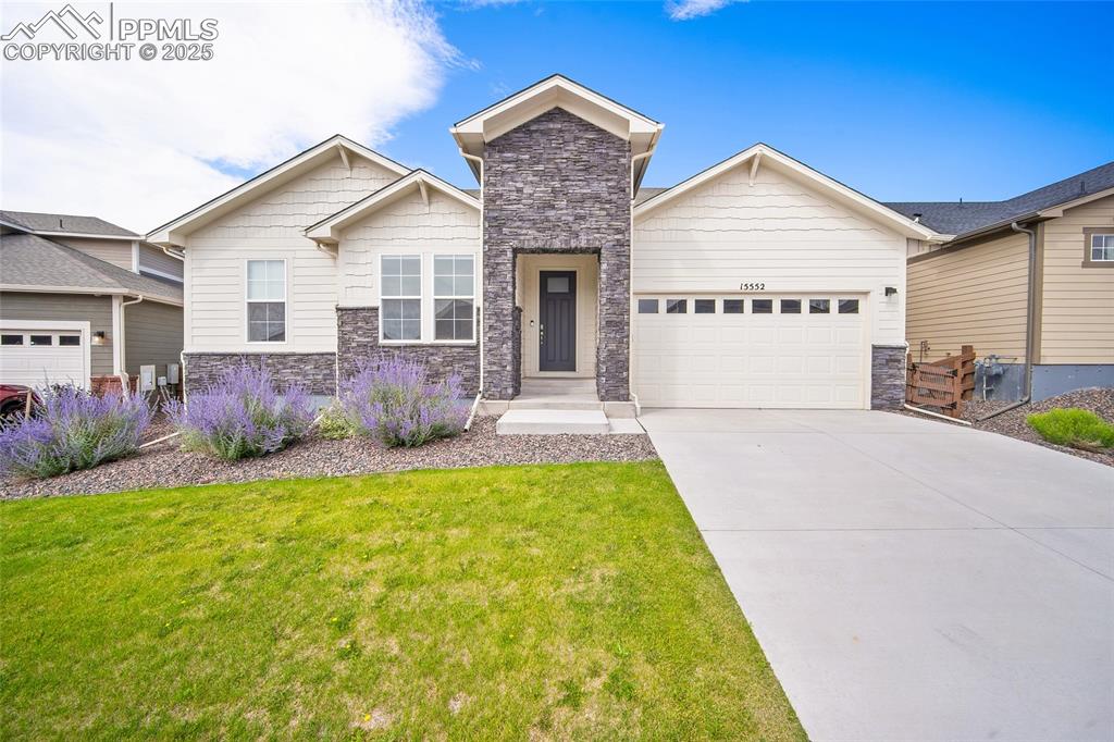Image 3 of 46: View of front of house featuring stone siding, a garage, driveway, and a fr