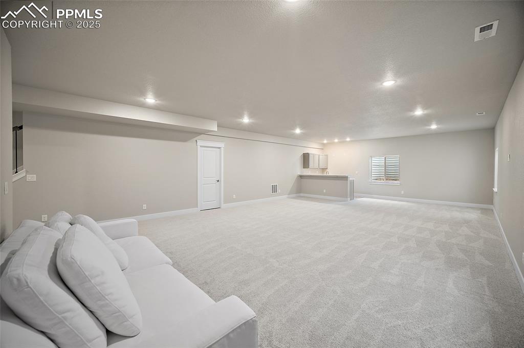 Image 37 of 46: Unfurnished living room featuring light colored carpet and recessed lightin