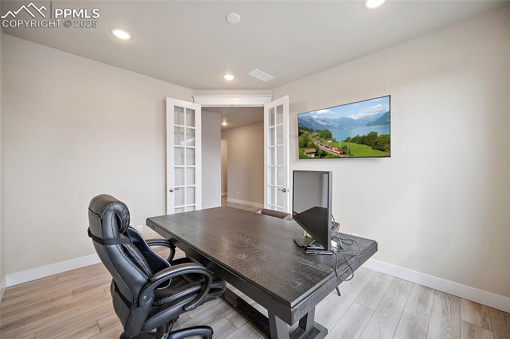 Image 7 of 46: Office area with french doors, recessed lighting, and light wood-style floo