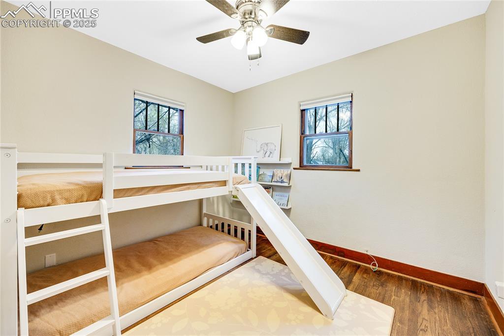 Image 12 of 34: Bedroom with baseboards, wood finished floors, multiple windows, and a ceil