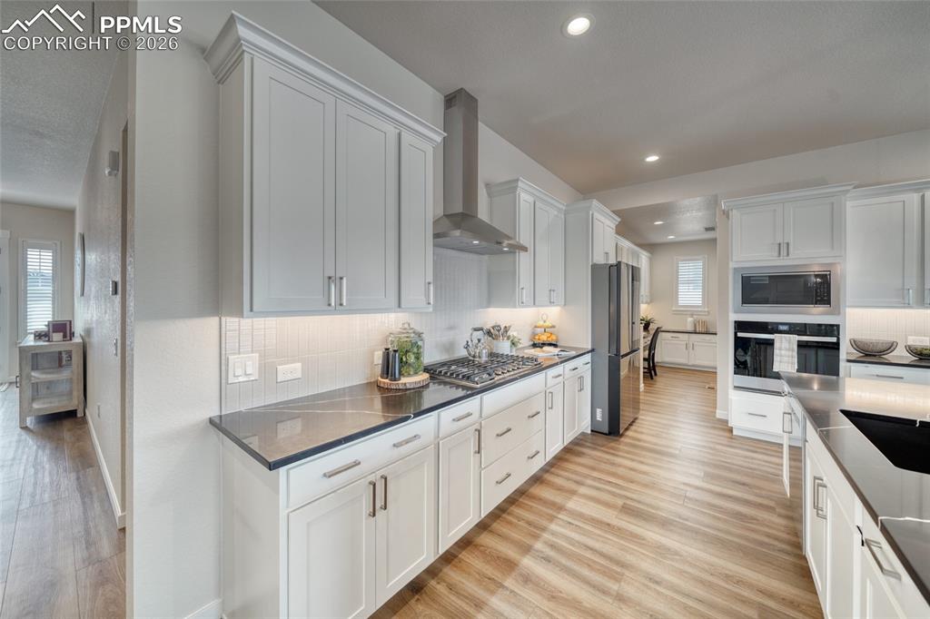 Image 15 of 50: Kitchen featuring stainless steel appliances, light wood-style floors, whit