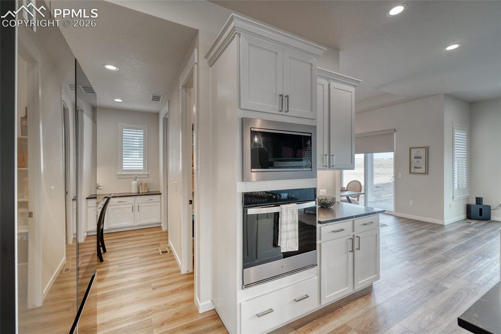 Image 16 of 50: Kitchen featuring white cabinetry, stainless steel appliances, light wood-t