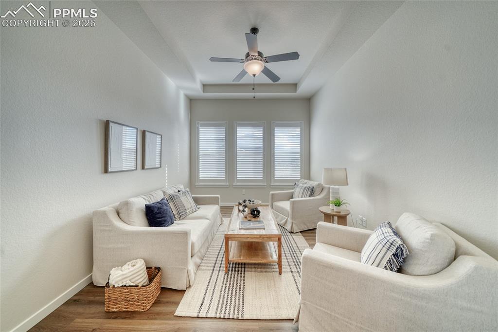 Image 27 of 50: Living room with ceiling fan, wood finished floors, a textured wall, and a