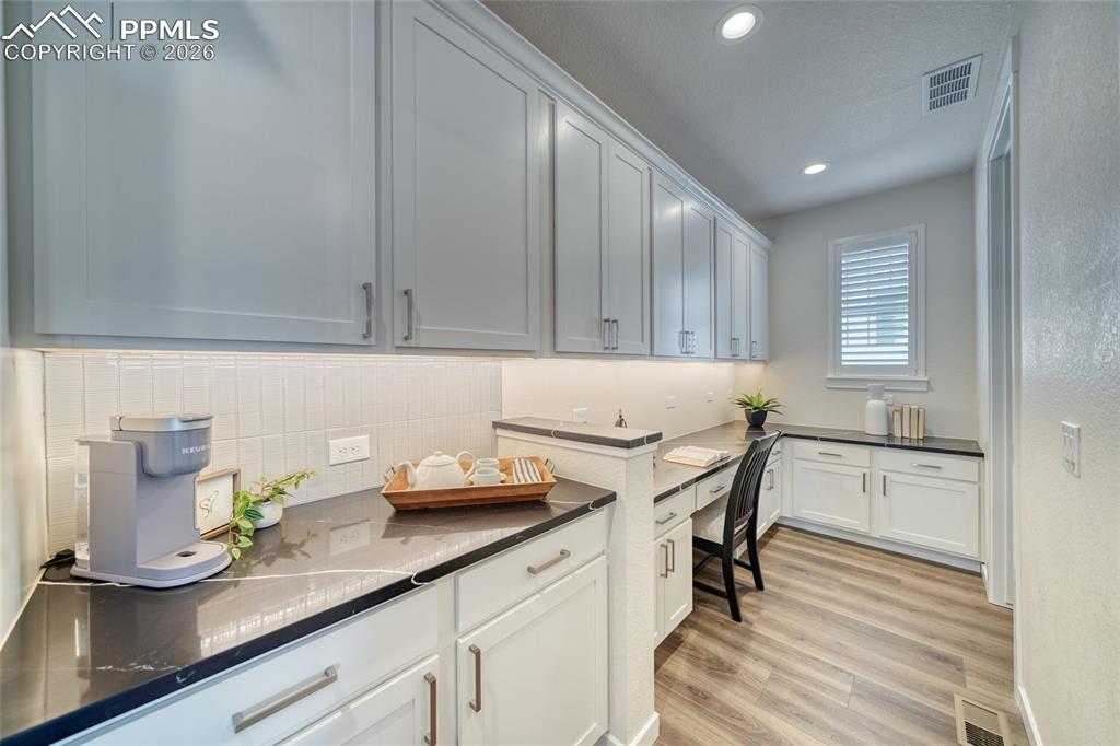 Image 28 of 50: Laundry room with light wood finished floors and recessed lighting