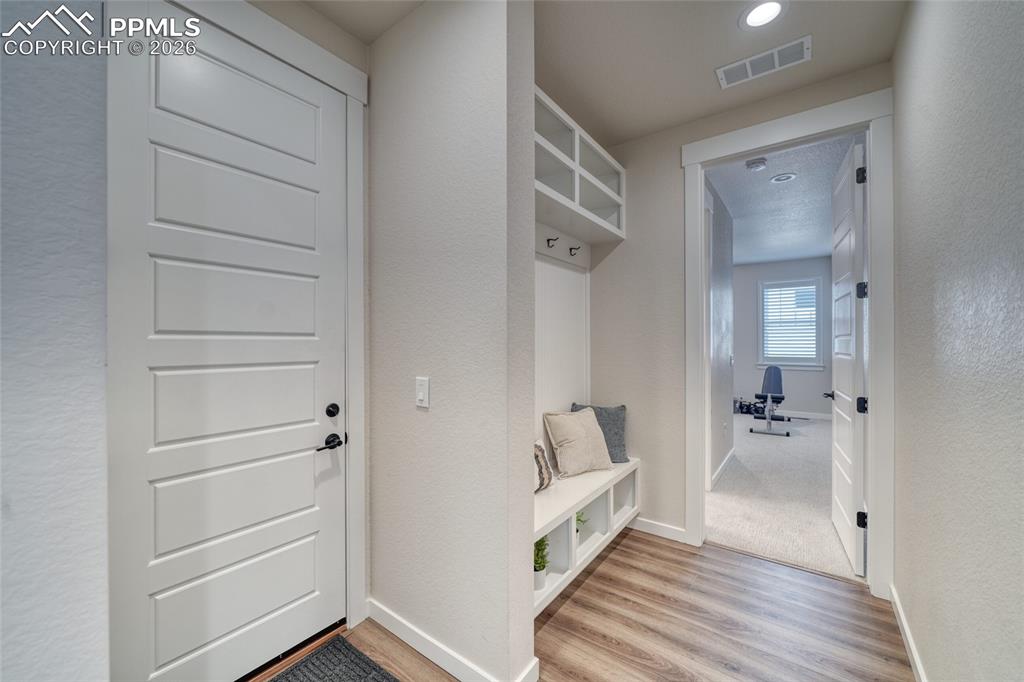 Image 31 of 50: Mudroom with light wood-style flooring and a textured wall