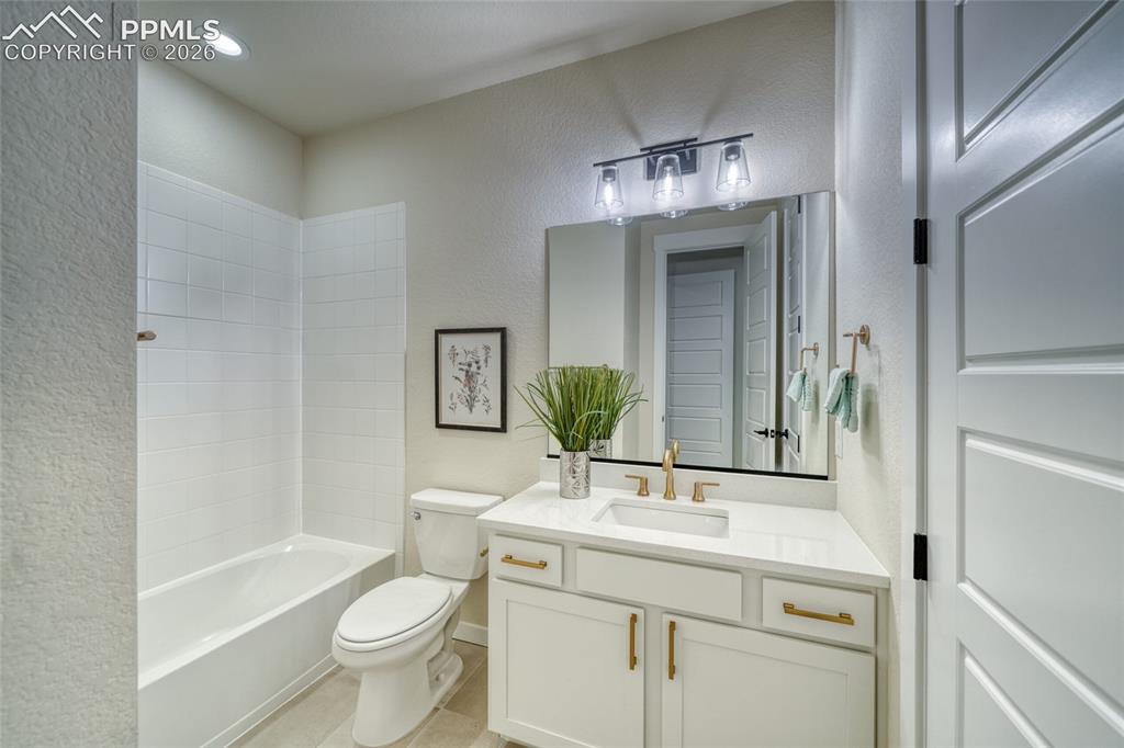 Image 32 of 50: Full bathroom with a textured wall, vanity, bathing tub / shower combinatio