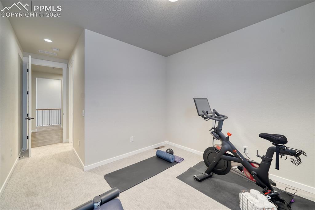 Image 34 of 50: Workout area with light carpet and recessed lighting