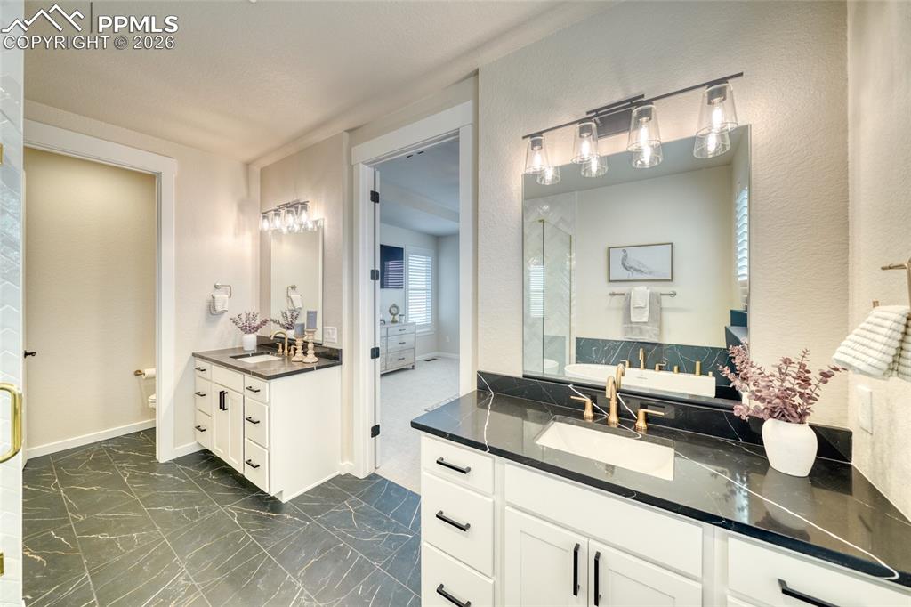 Image 39 of 50: Bathroom featuring toilet and two vanities