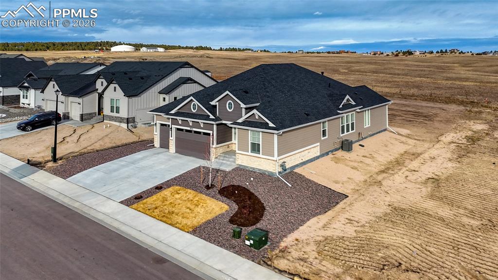 Image 4 of 50: View of front of house with concrete driveway, stone siding, and an attache