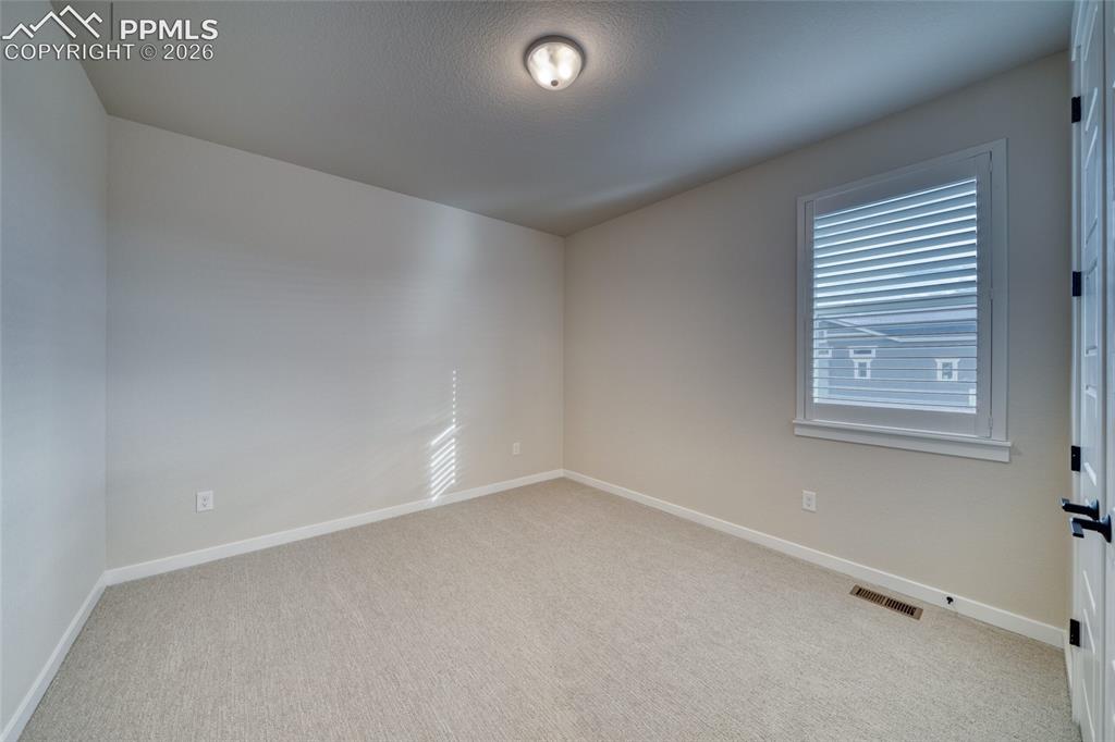 Image 42 of 50: Unfurnished room with baseboards and light carpet
