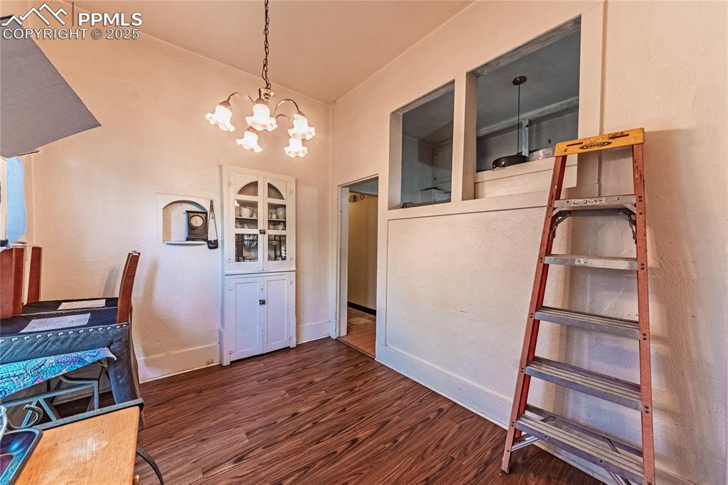 Image 10 of 22: Front Unit, Dining area featuring wood finished floors and a chandelier