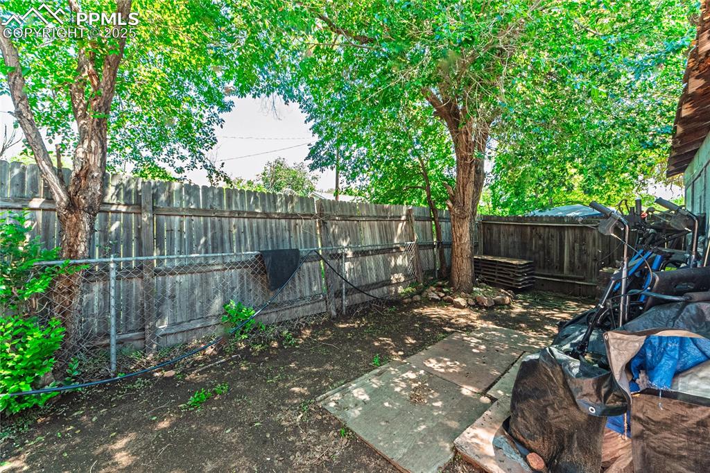 Image 18 of 22: Fenced backyard with a patio