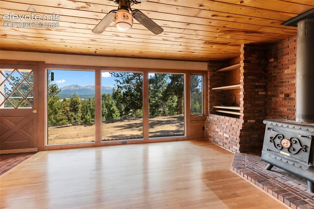 Image 2 of 46: Expansive floor-to-ceiling windows featuring mountain and tree scenery