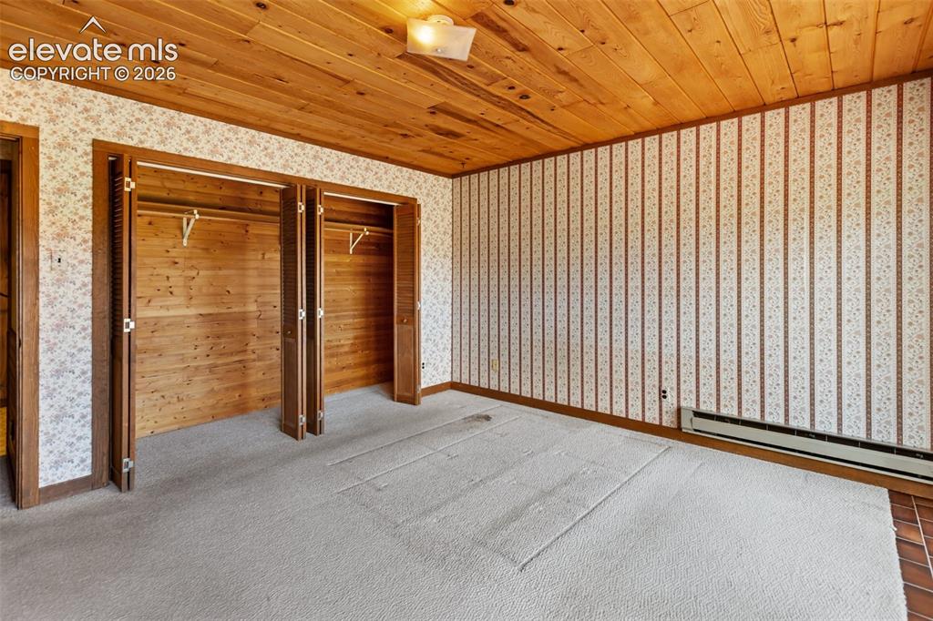 Image 20 of 46: Room featuring wood-planked ceiling, patterned wallpaper, and light-toned c