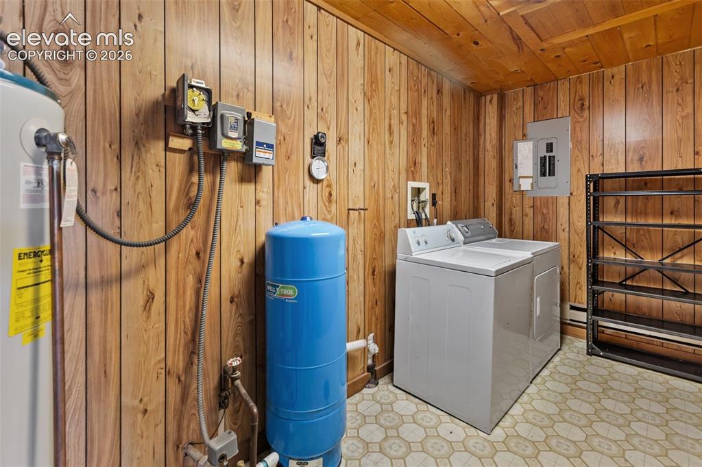 Image 26 of 46: Utility room featuring wood-finish paneling, a patterned vinyl floor, cloth