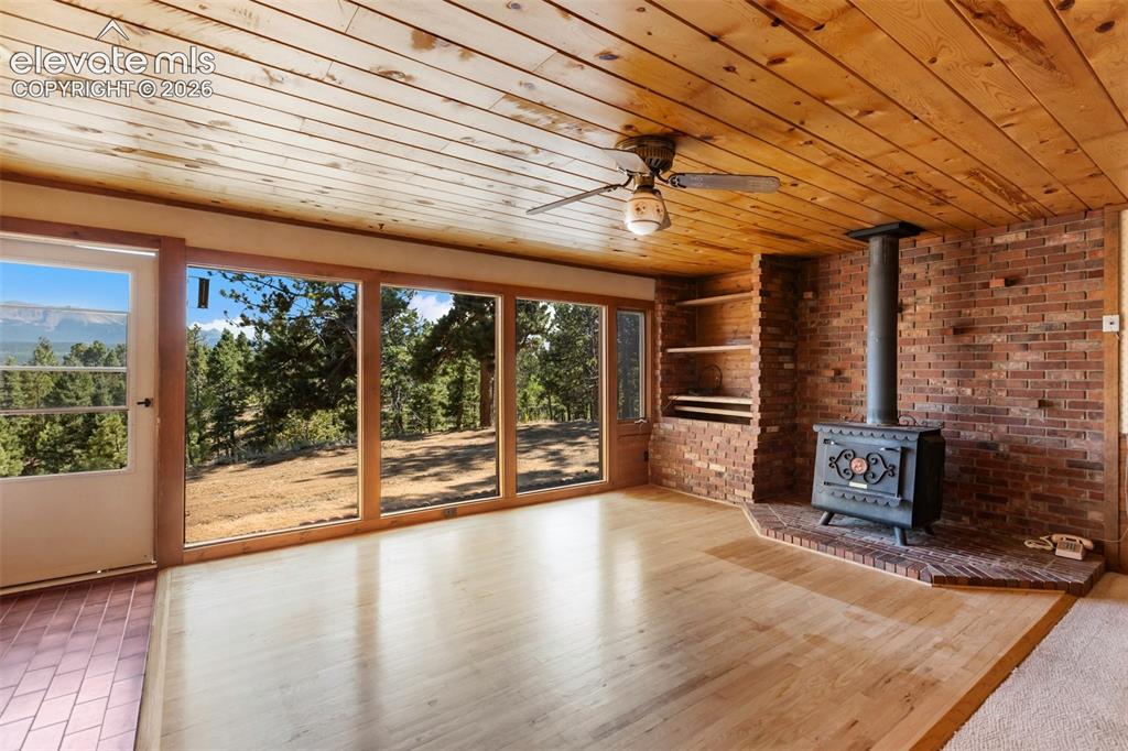 Image 4 of 46: Expansive window wall overlooking mountainous terrain and mature trees