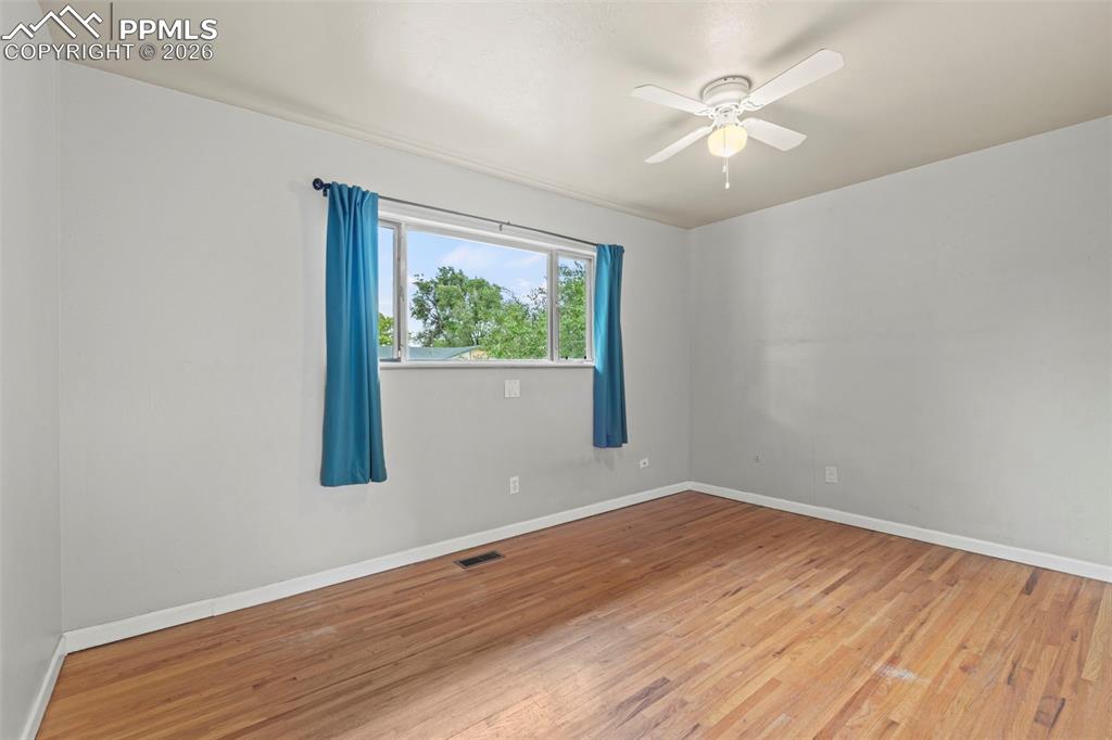 Image 13 of 28: Spare room featuring hardwood / wood-style floors and ceiling fan