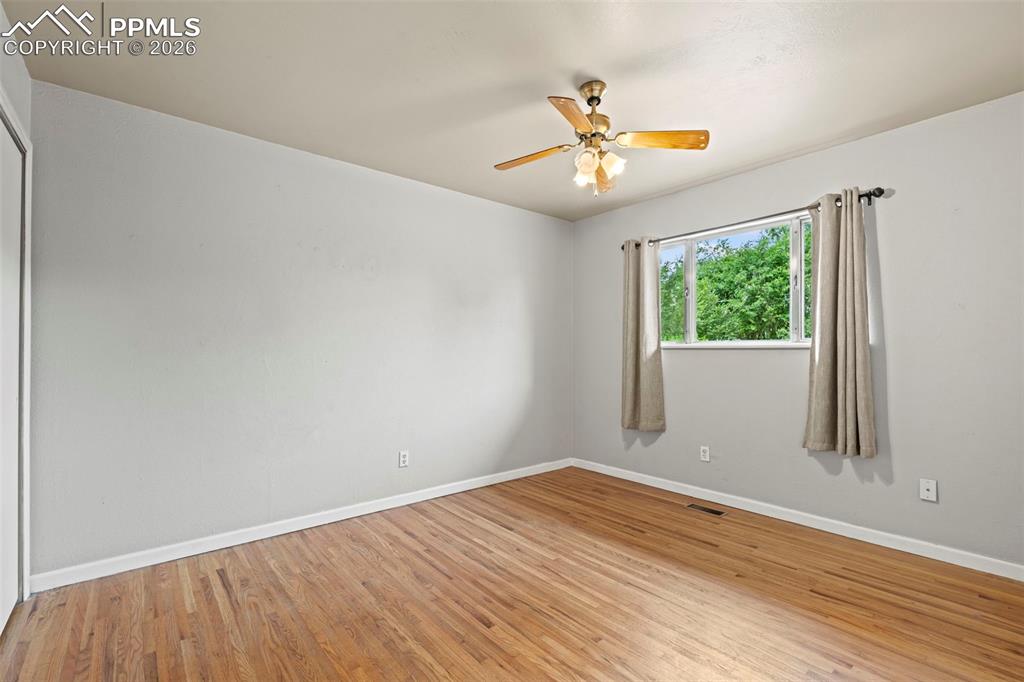 Image 17 of 28: Empty room featuring light wood-style floors and ceiling fan