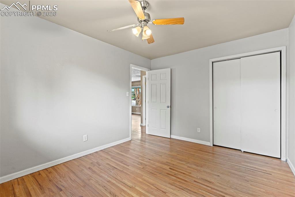 Image 18 of 28: Unfurnished bedroom with a ceiling fan, light wood finished floors, and a c