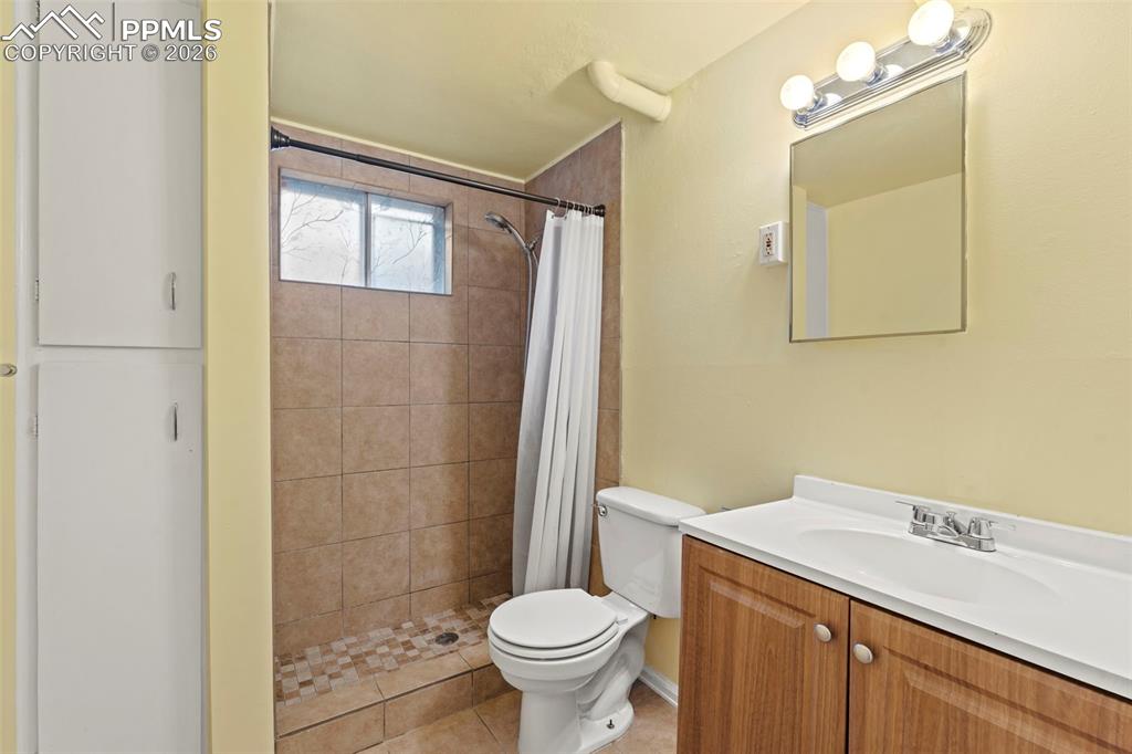 Image 23 of 28: Bathroom with vanity, a shower stall, and light tile patterned floors