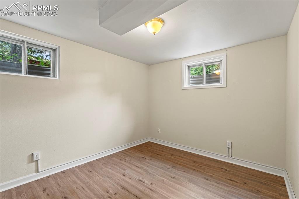Image 24 of 28: Unfurnished room featuring wood finished floors and baseboards