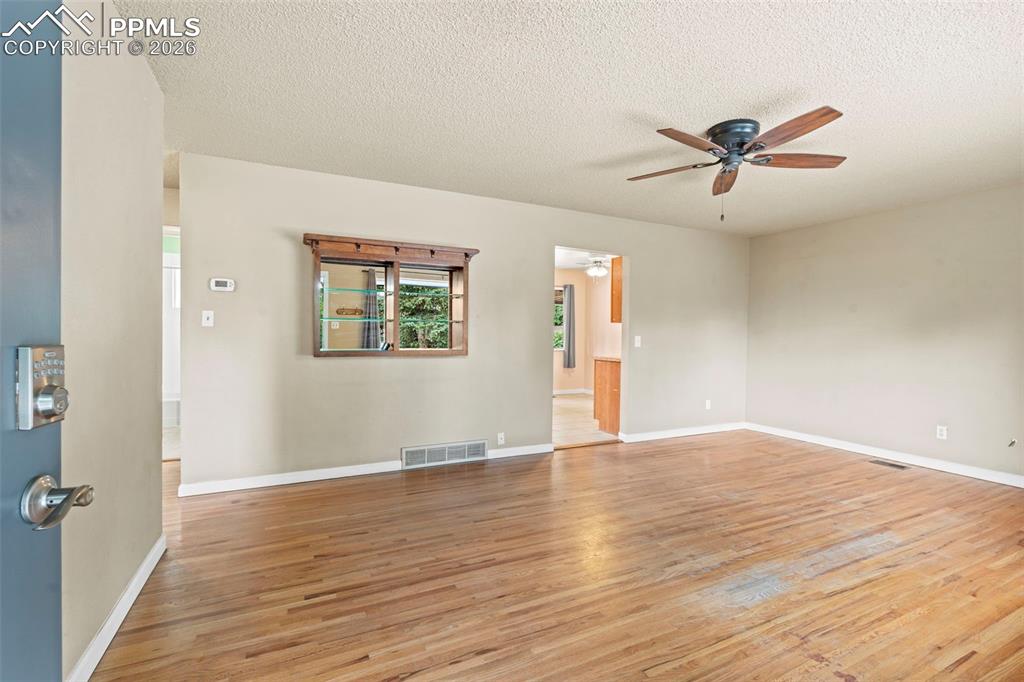 Image 5 of 28: Empty room with light wood-style floors, a textured ceiling, and a ceiling 