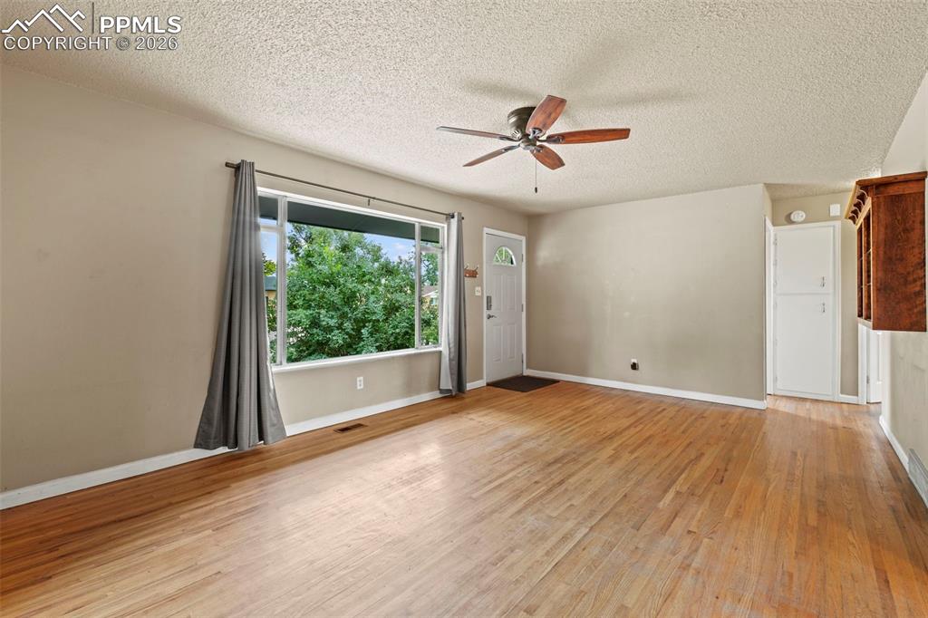 Image 7 of 28: Unfurnished room featuring light wood-style flooring, ceiling fan, and a te