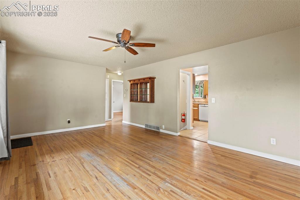 Image 8 of 28: Empty room featuring light wood-type flooring, a textured ceiling, and ceil