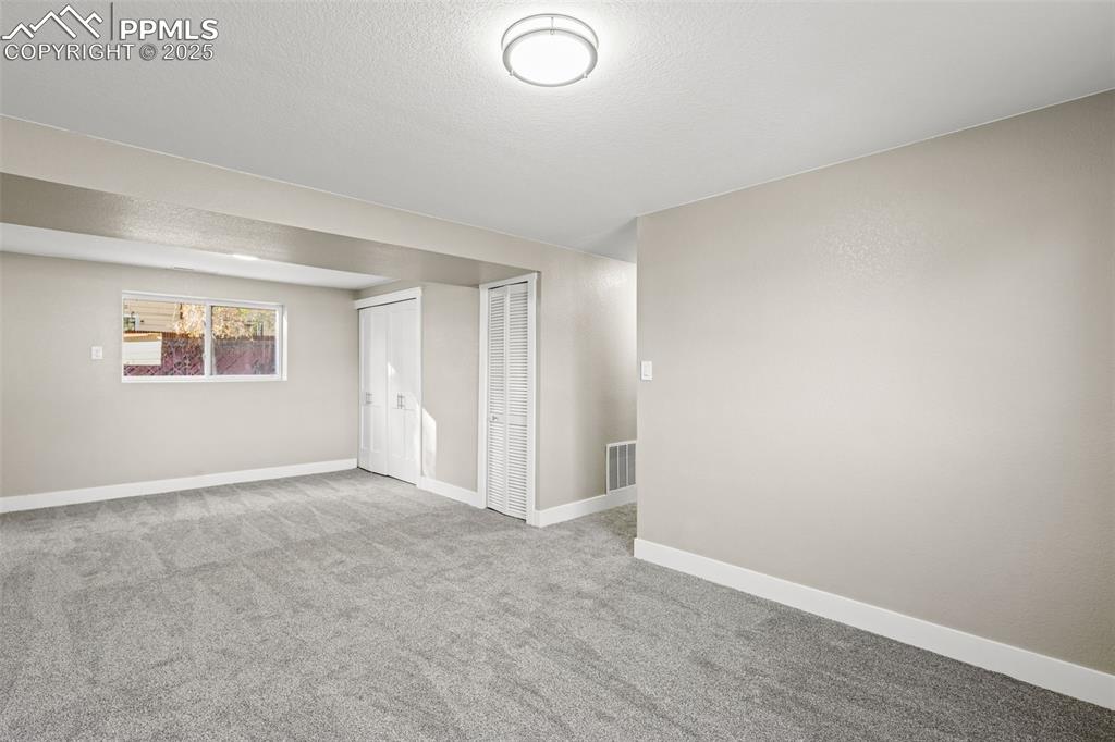 Image 10 of 15: Below grade area with carpet floors and a textured ceiling