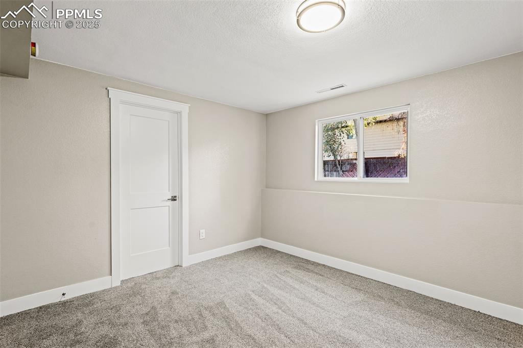 Image 12 of 15: Carpeted spare room featuring baseboards and a textured ceiling
