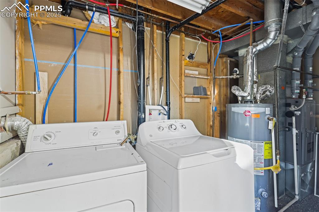 Image 14 of 15: Laundry room with water heater and washing machine and dryer