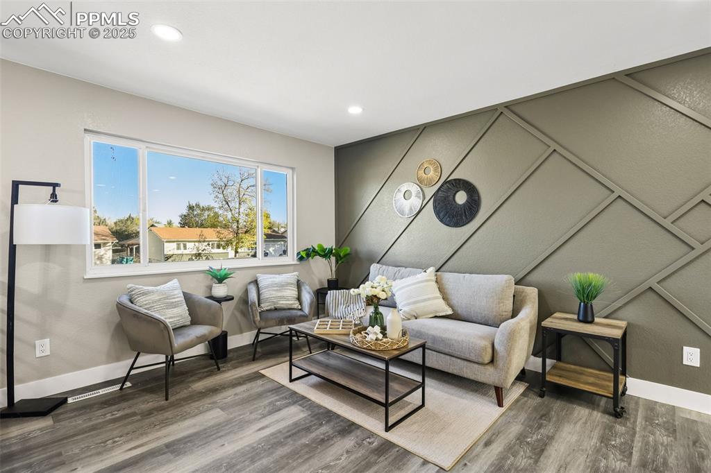 Image 3 of 15: Sitting room featuring wood finished floors, a decorative wall, and recesse