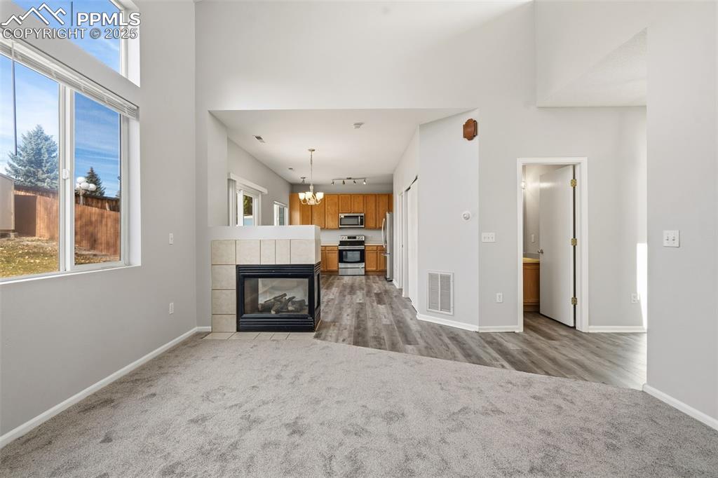 Image 6 of 25: Beautiful 3 sided gas log fireplace to warm the main level