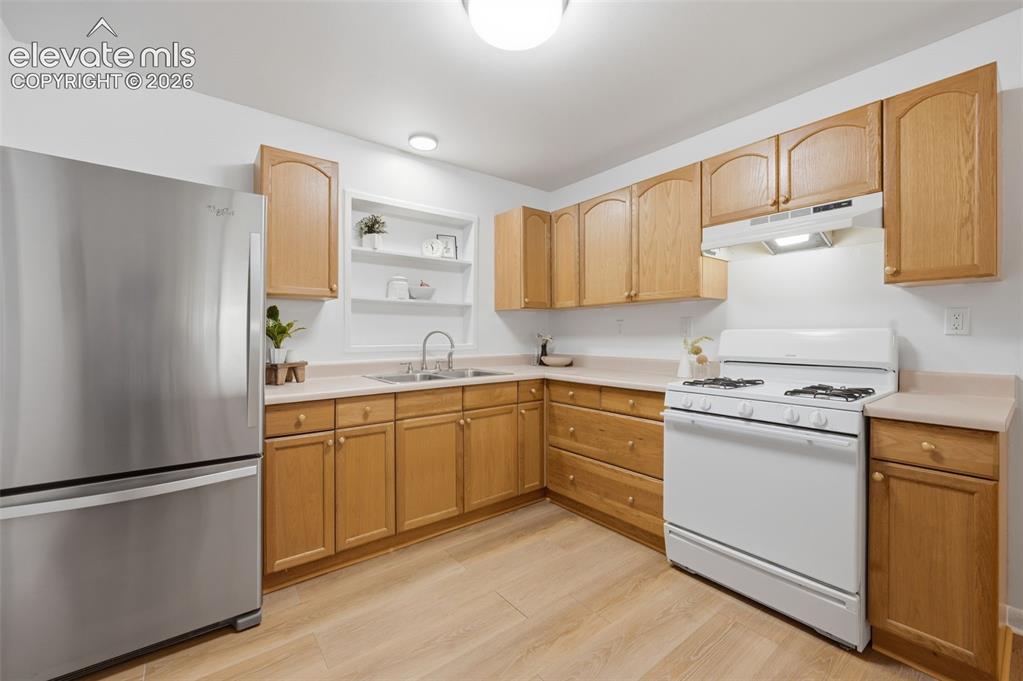 Image 11 of 38: Kitchen featuring wood-finish cabinetry, a double basin stainless steel sin