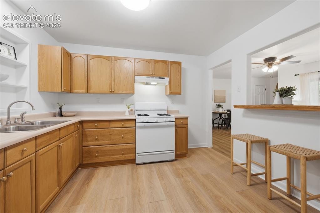 Image 12 of 38: Kitchen pass-through with a wood-finish bar and overhead recessed lighting
