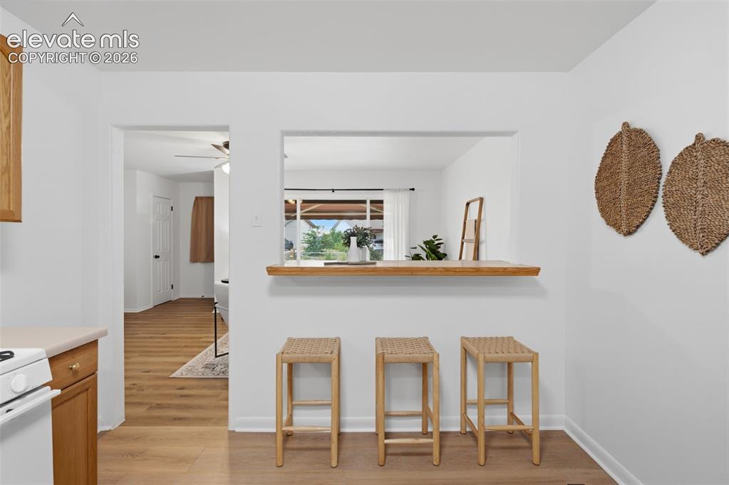 Image 13 of 38: Bright room featuring wood-finish flooring, white walls, and a multi-pane w