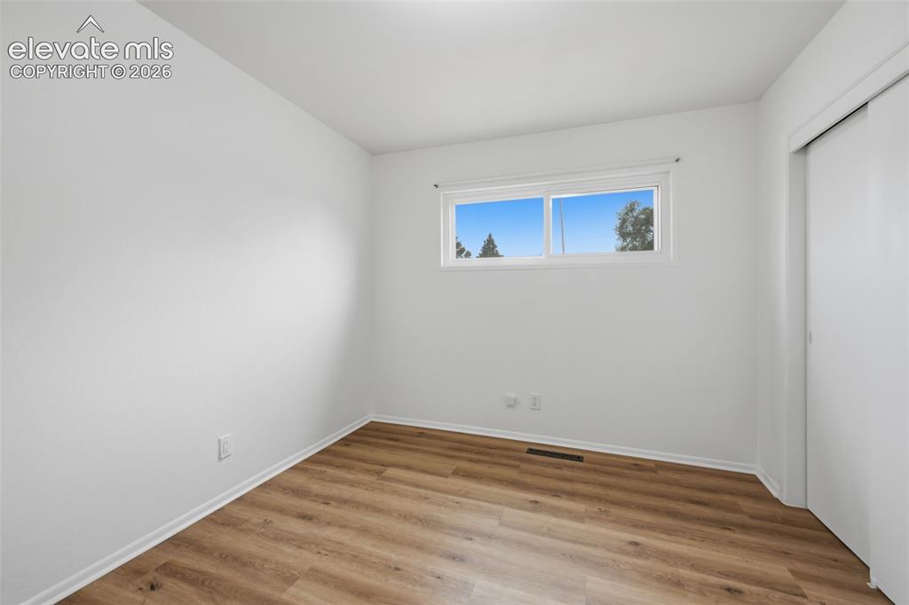Image 17 of 38: Room featuring wood-finish flooring, white walls, and white trim