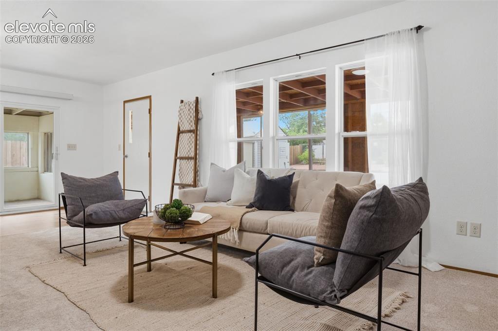 Image 25 of 38: Open-concept living space featuring light-colored carpeting, a kitchen with
